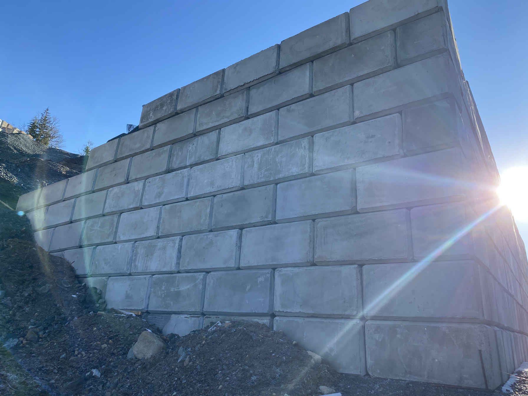 Tall interlocking concrete block wall in sunlight
