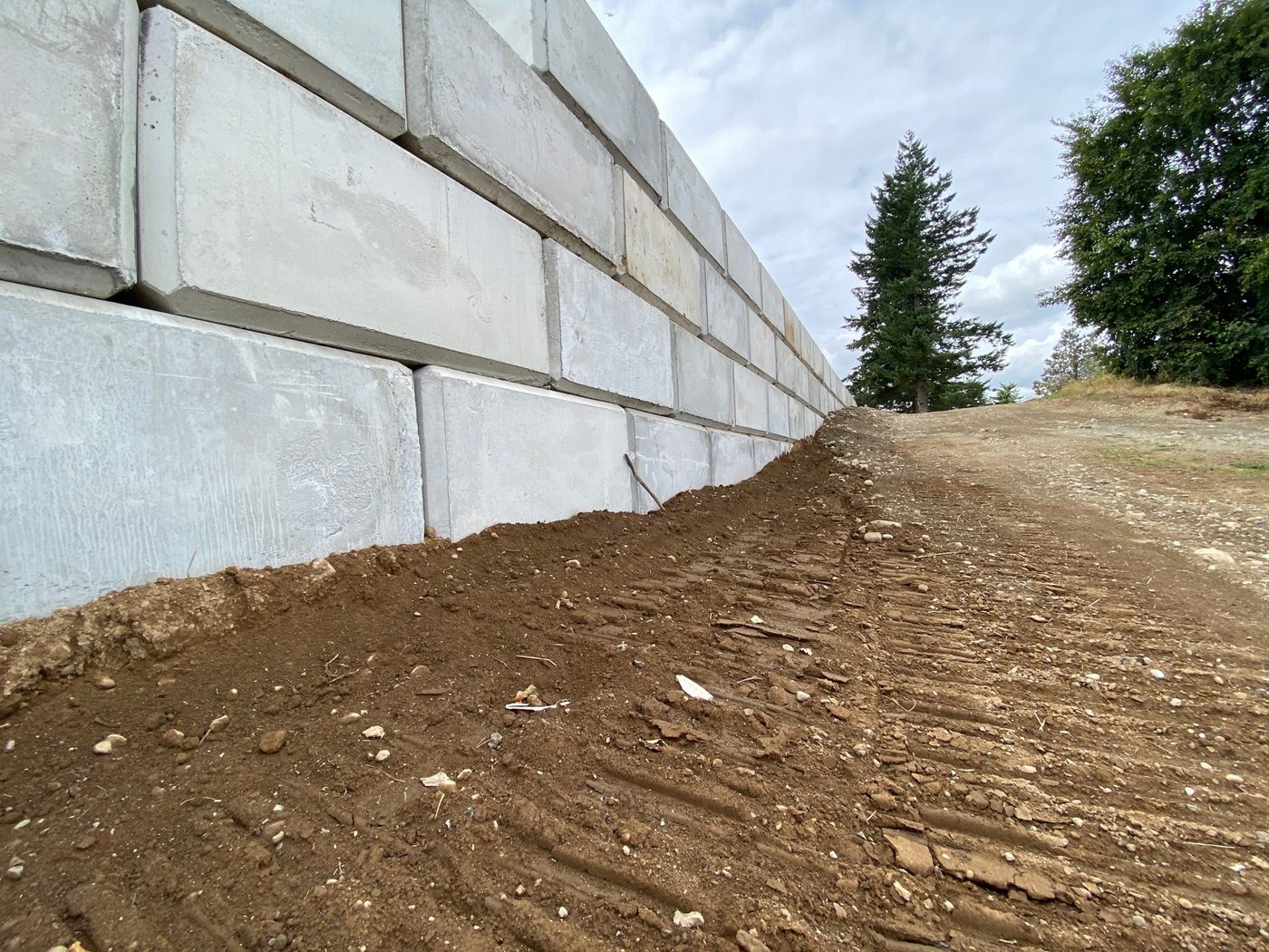 Interlocking concrete block retaining wall along a job-site road